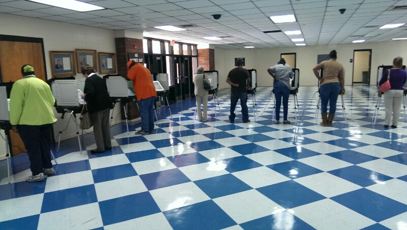 People casting their ballots on electronic voting machines at the Decatur County Memorial Coliseum