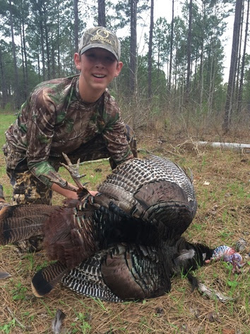 A young hunter with his harvested turkey.